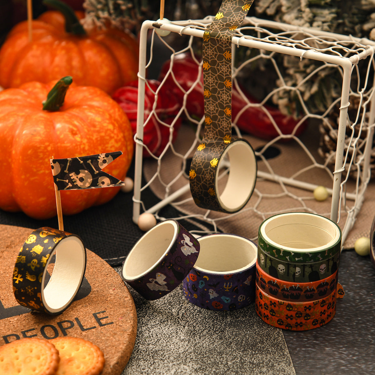 Decorative Halloween masking tape rolls styled with mini pumpkins and craft props