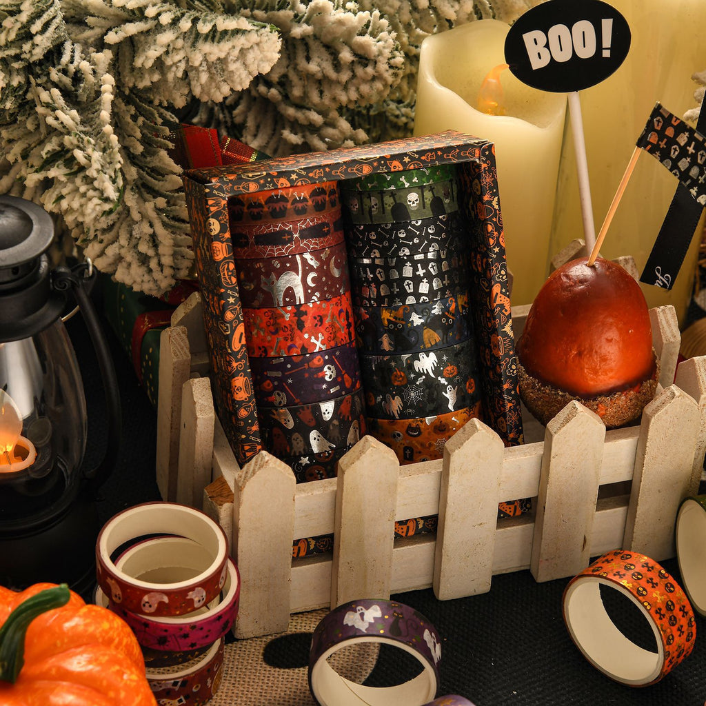 Halloween washi tape rolls arranged by a white fence with spooky pumpkin decor