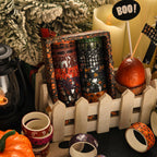 Halloween washi tape rolls arranged by a white fence with spooky pumpkin decor