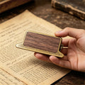 Hand holding walnut wood journal clip showing wood grain face