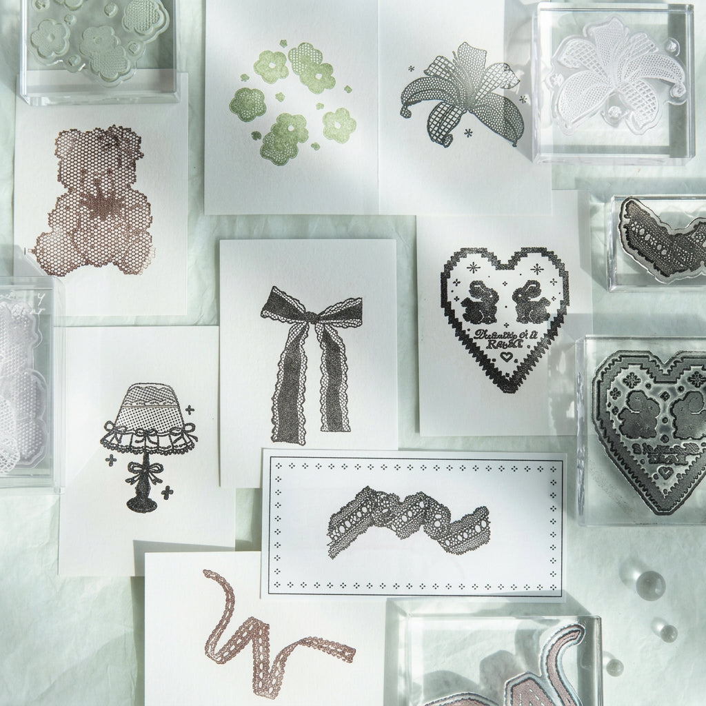 All eight handmade lace acrylic stamp designs arranged in a flat grid – bow, heart, lamp, bear, lily, lace trims