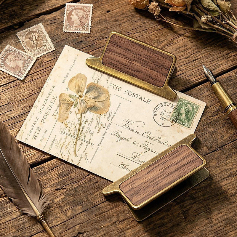 Walnut wood clip holding botanical journal page flat in use