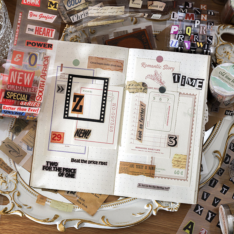 Open junk journal with vintage ephemera tape collaged pages featuring ticket borders headline stickers and handwritten labels