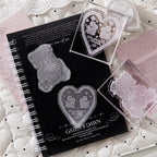 Bunny heart lace stamp impressions on black journal pages with scattered clear stamps