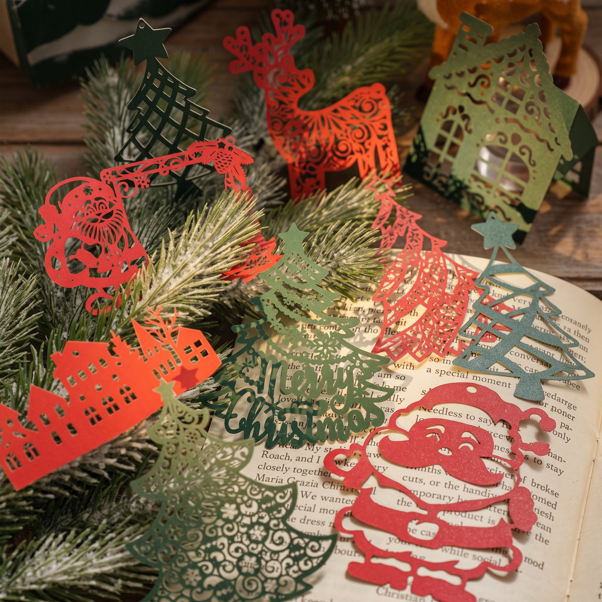  Red and green laser cut Christmas paper pieces with reindeer, trees and Santa on pine branches