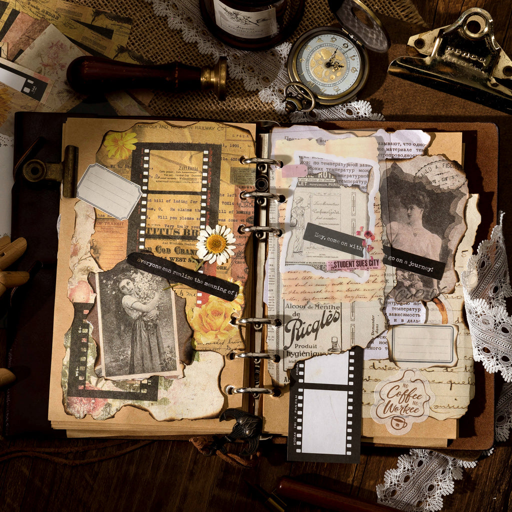 Open vintage journal with ephemera kit layered collage including film strips and antique labels