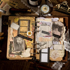 Open vintage journal with ephemera kit layered collage including film strips and antique labels