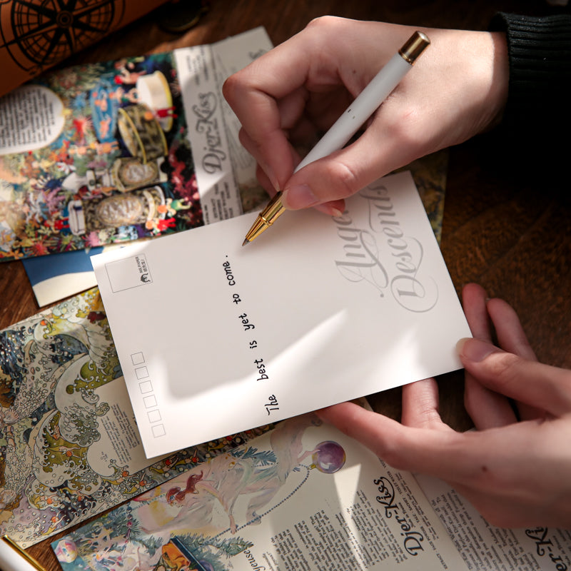 Hand writing on lined back of vintage postcard with fountain pen, showing mail-ready correspondence side and floral illustration front for pen pal letters
