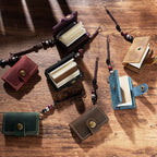 Seven mini leather traveler's notebook charms with bead cords on wooden desk