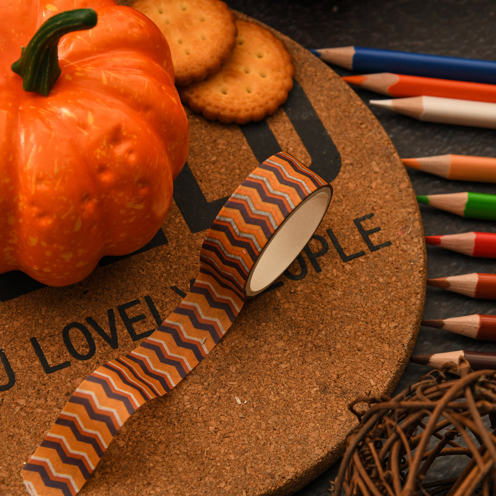 Close-up of Halloween washi tape rolls beside orange pumpkins