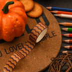 Close-up of Halloween washi tape rolls beside orange pumpkins