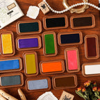 Open vintage ink tins showing the color pads in a grid on wood