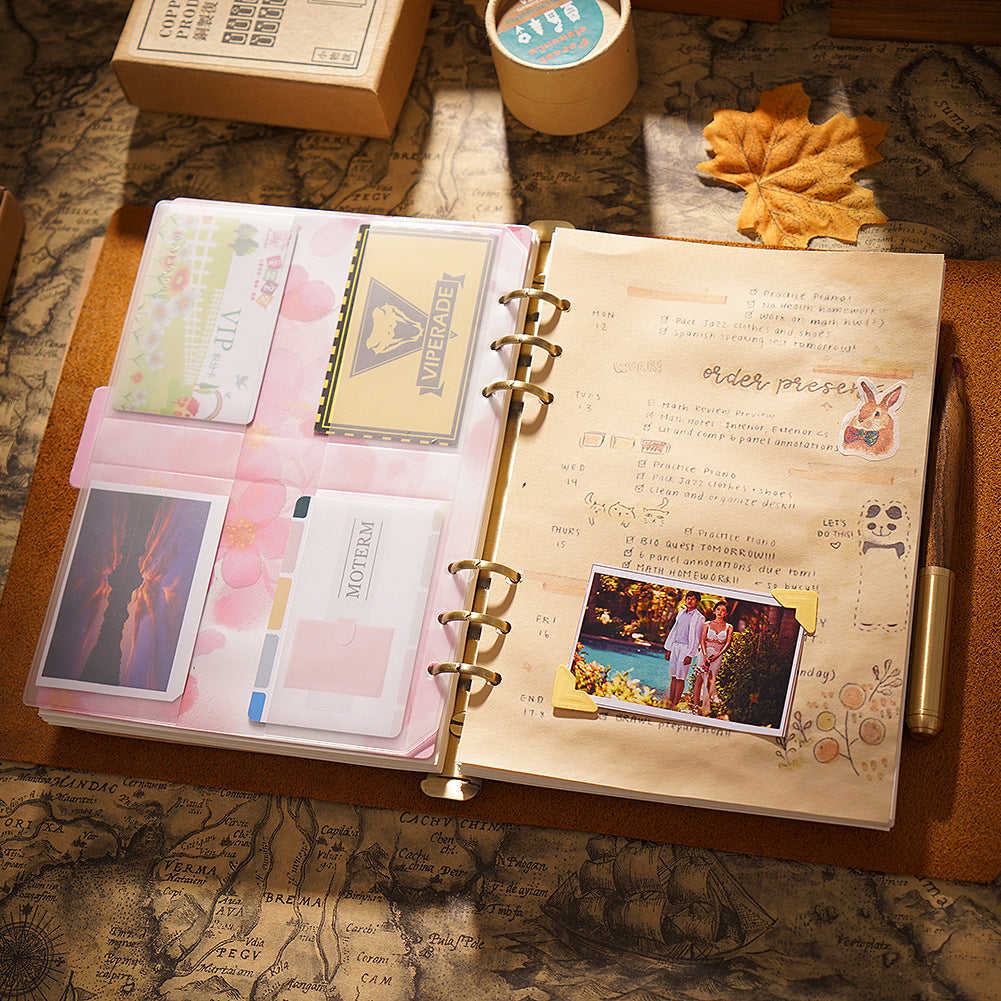 Open leather journal showing ring binder mechanism with decorative washi tape and photo collage
