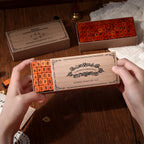Hands opening a kraft box of vintage wooden alphabet stamps with rubber letter blocks inside