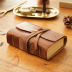 Pocket leather sketchbook on wooden desk with brass wax seal stamp