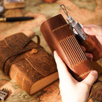 Holding pocket leather sketchbook with fountain pen showing size in hand