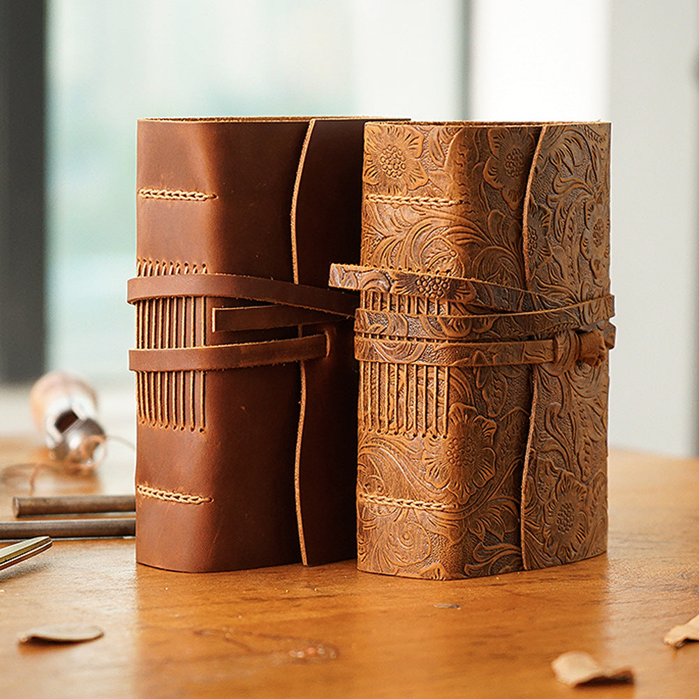 Two pocket leather sketchbooks standing, plain and carved brown covers
