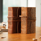 Two pocket leather sketchbooks standing, plain and carved brown covers