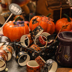 Halloween washi tape rolls scattered among mini pumpkins and autumn decor