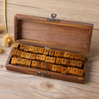 Wooden alphabet stamp set in keepsake box, serif letter blocks on rustic wood background