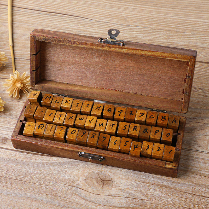 Wooden alphabet stamp set in keepsake box, serif letter blocks on rustic wood background