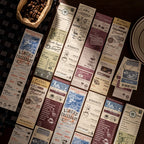 All six vintage coffee notepad designs fanned out on dark surface with coffee beans, showing almond croissant, city roast, floral brand, and colombian bread cafe ephemera prints