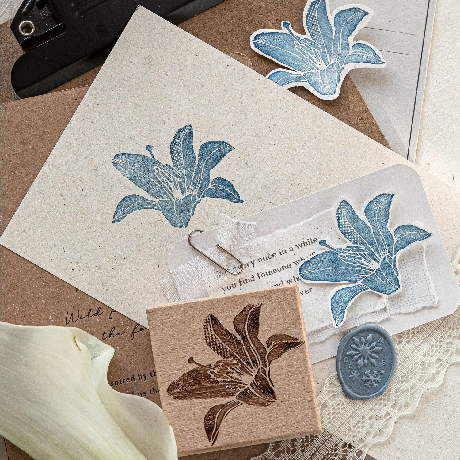 Scattered vintage stamp impressions and beech wood stamps on neutral background, blue leaf print, script text, and botanical ink patterns for planner spreads
