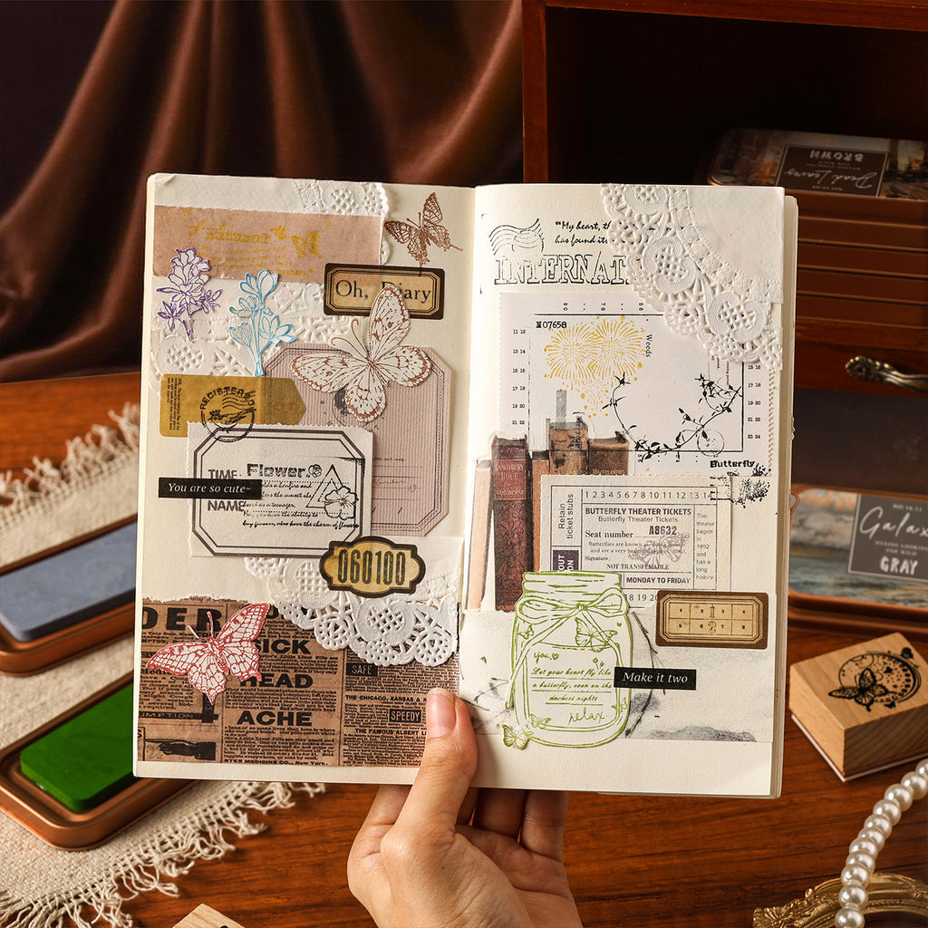 Open junk journal with stamped pages, washi tape and ink pads beside