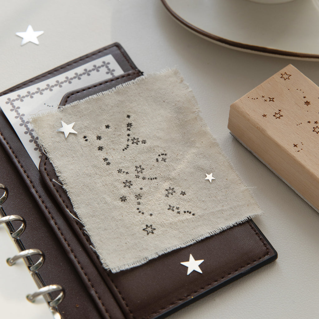 Vintage star constellation rubber stamps on white background with carved beech wood base and star date marker impressions, natural wood grain for celestial journal spreads