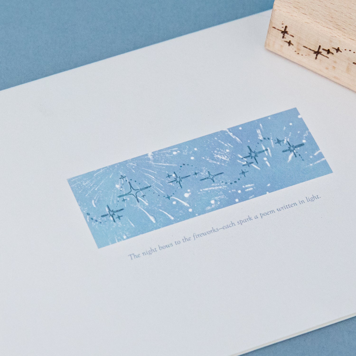 Star trail transparent impression on blue background with scattered stardust and celestial border design, carved rubber constellation stamp print for scrapbook layering