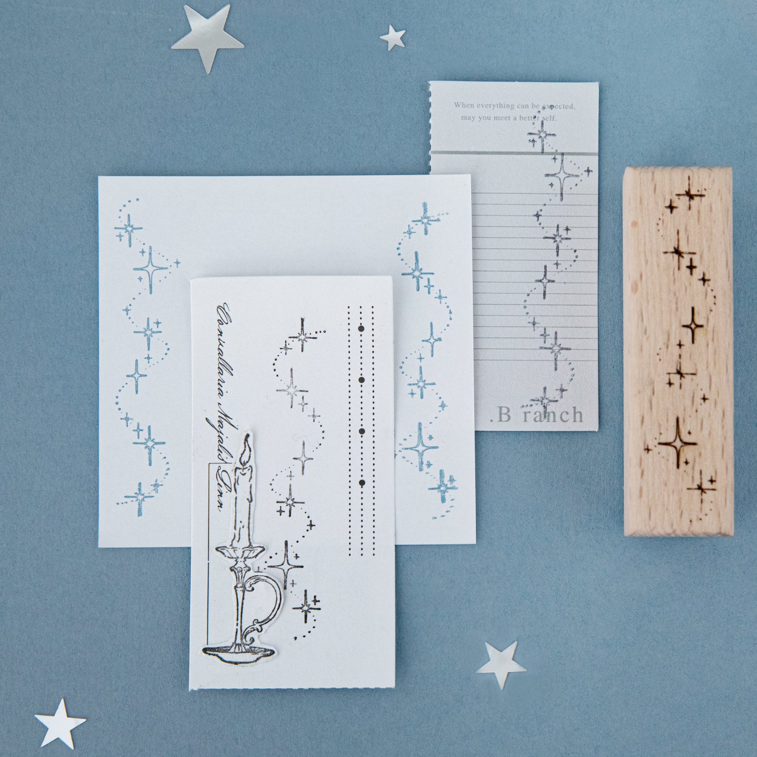 Starlight sonata beech wood stamp with carved rubber constellation impression on blue background, printed card showing star trail design for planner decoration