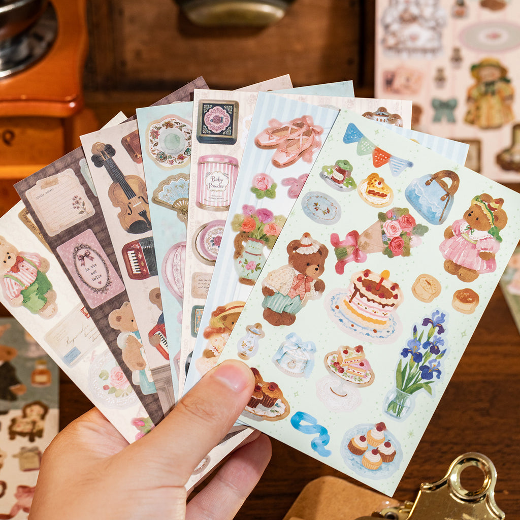 Hand fanning out teddy bear sticker sheets with vintage floral and bear designs