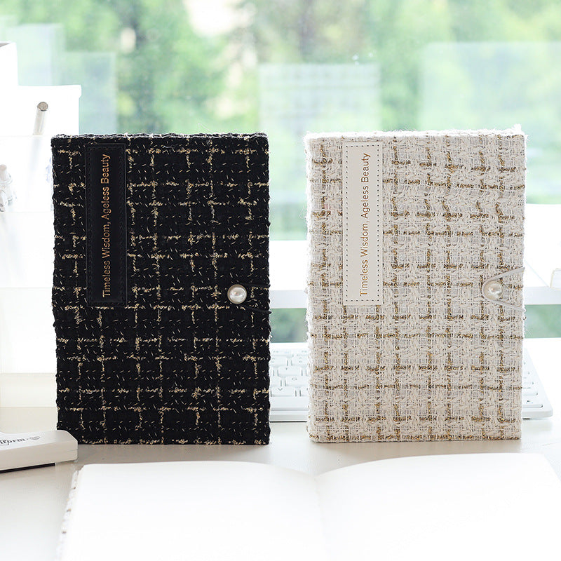 Black and white tweed journals standing side by side on a windowsill