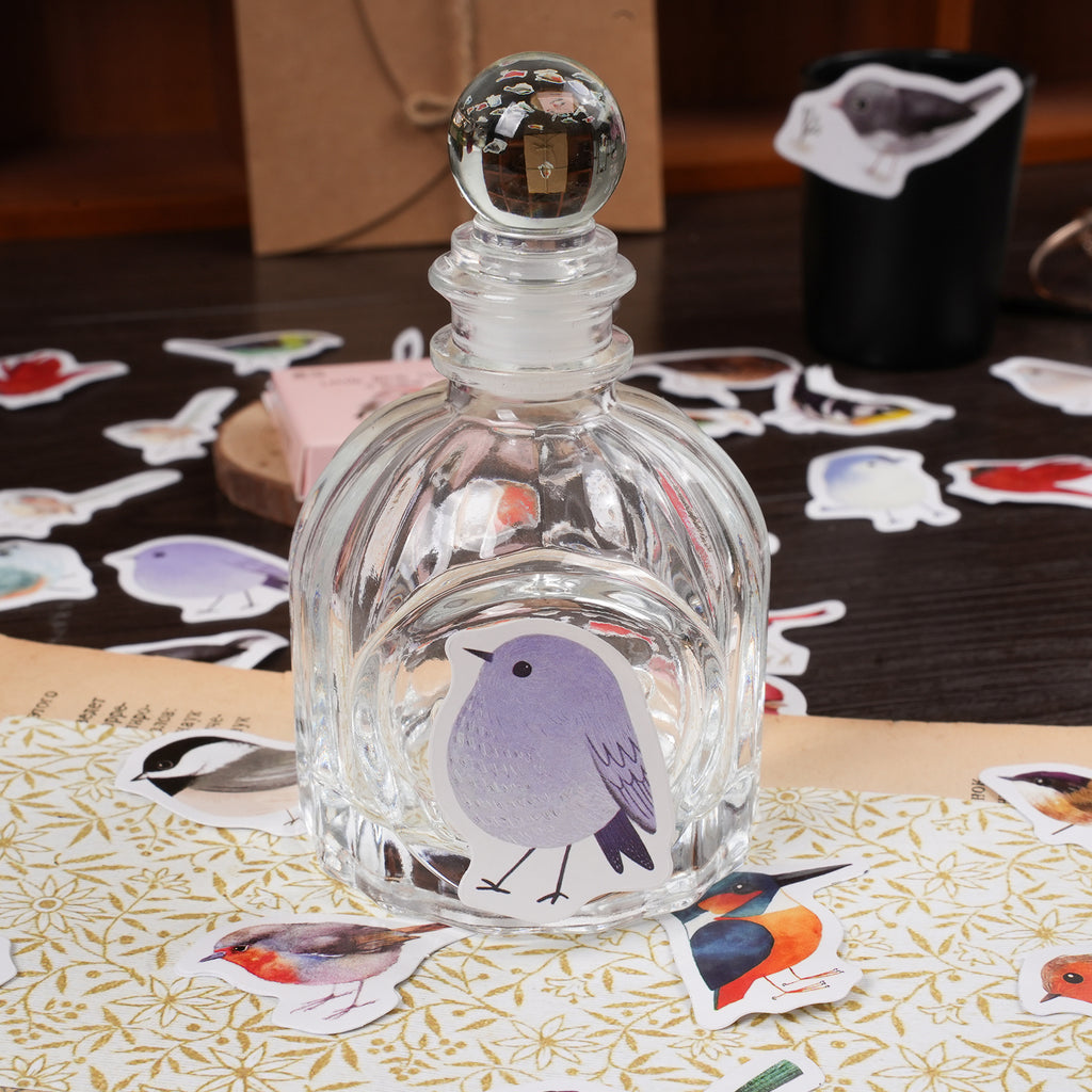 Close-up of vibrant watercolor bird stickers featuring cute robins, sparrows and nature-inspired artwork