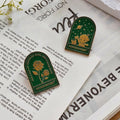 Green embossed rose binder clips on vintage book pages