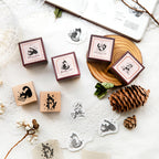 Set of six vintage cat wooden rubber stamps with beech handles on a white desk with pine cones and botanical accents, showing printed cat impressions for junk journaling
