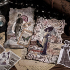 Two vintage collage cards placed on a black typewriter, layered with character stickers, butterfly cutouts, and delicate lace borders over aged manuscript paper.