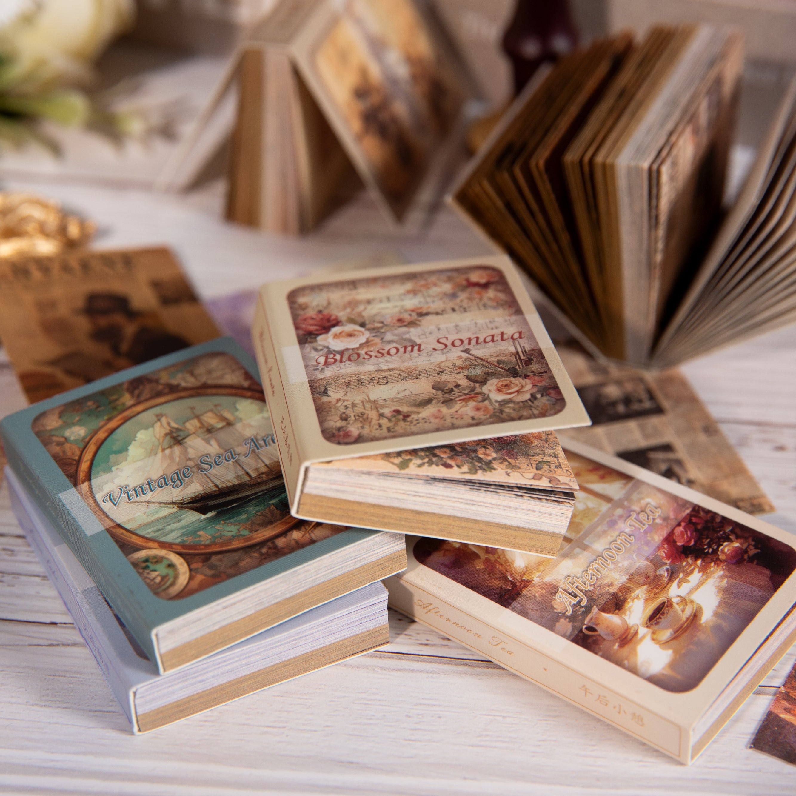 Scattered vintage ephemera cards with mixed patterns of script text, florals, and antique borders on paper.