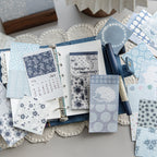 Vintage ephemera paper sheets used in journal collage spread with botanical calendar and floral prints, mixed lightweight paper and PET overlays for scrapbook layering