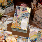Vintage floral illustration boxed postcards with sealed packaging and scattered cards, romantic botanical designs with gold decorative borders on premium white cardstock