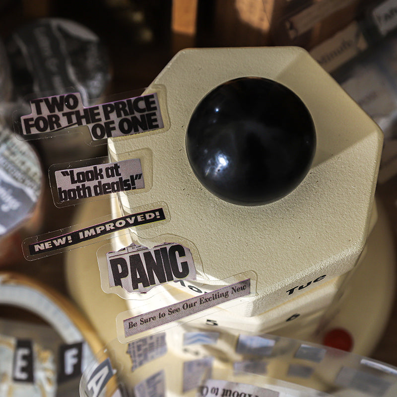 Bold vintage headline fragments from PET tape stuck on cream retro object showing PANIC and TWO FOR THE PRICE OF ONE text