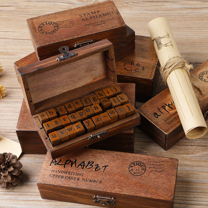 Vintage alphabet letter stamps in a walnut wooden keepsake box with metal latch, blocks and closed box flat lay