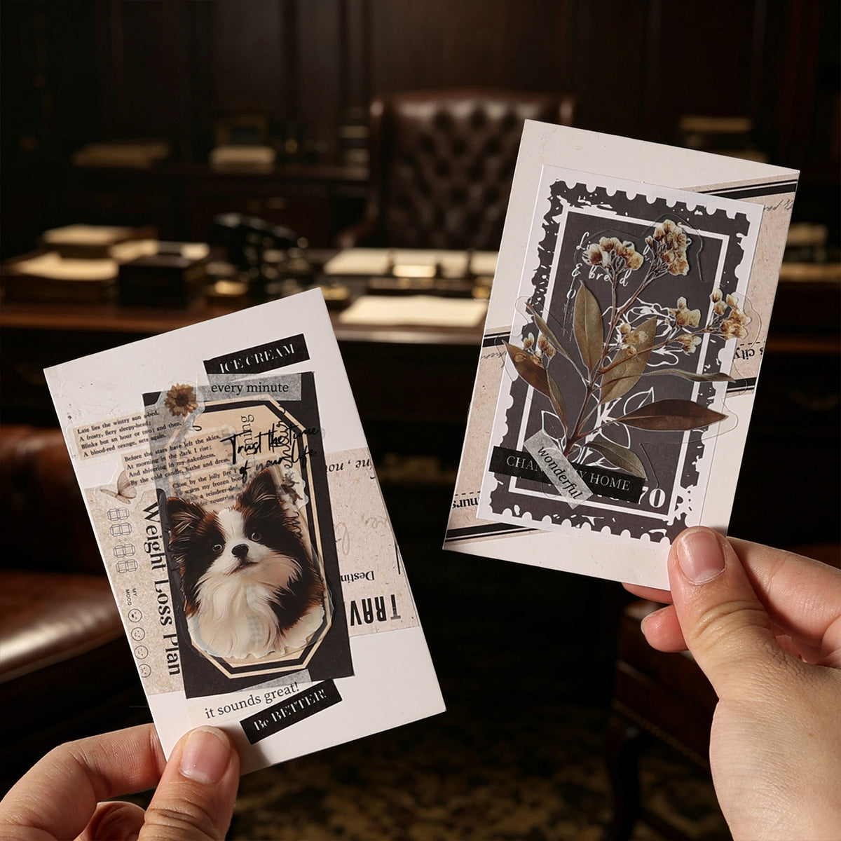 Two hands holding completed junk journal collage cards using vintage letter stickers — dog portrait with typewriter text and botanical stamp layering