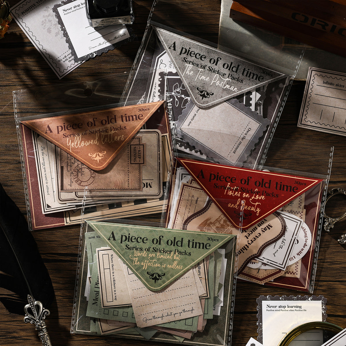 Four vintage letter sticker packs spread on dark wood desk — Yellowed Letters, The Time Postman, Notes on Love and Beauty, and Words Are Limited themes