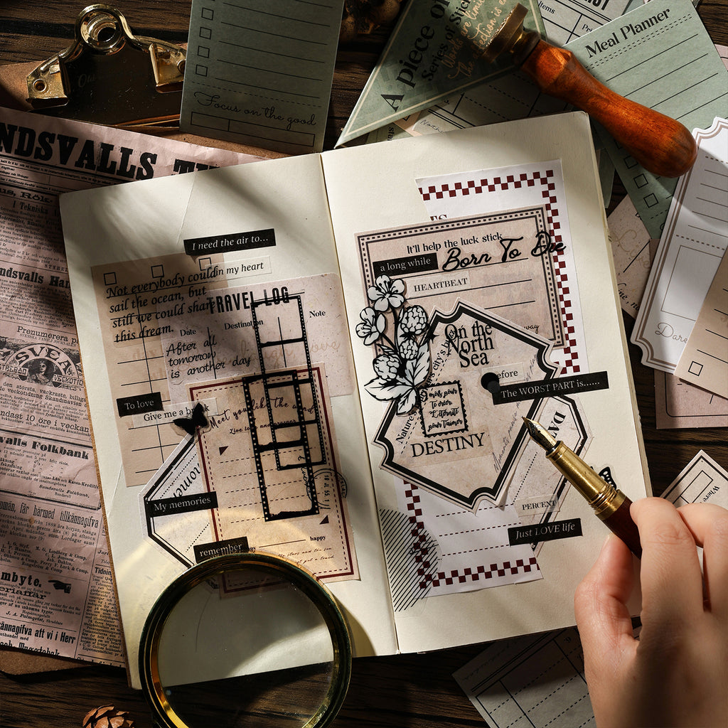 Open journal spread decorated with vintage letter stickers — travel log forms, typography labels and botanical frames layered over aged newsprint background