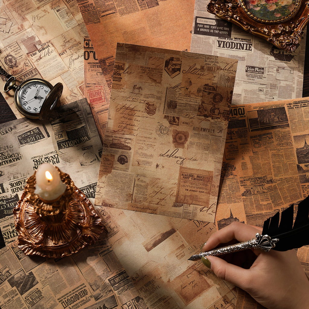 Distressed vintage newspaper print art paper sheets from the collage kit, styled with a lit candle, antique pocket watch and feather quill pen