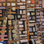 Close-up of clear PET tape with vintage ticket stubs luggage labels and handwritten fragments in sepia and cream tones