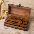 Vintage wooden stamp box with metal latch open, full alphabet blocks in warm wood tones