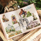 Open sticker booklet displaying vintage world stickers applied to pages, featuring greenhouse garden, guitar player, floral house, and manor house illustrations, journal ephemera in use