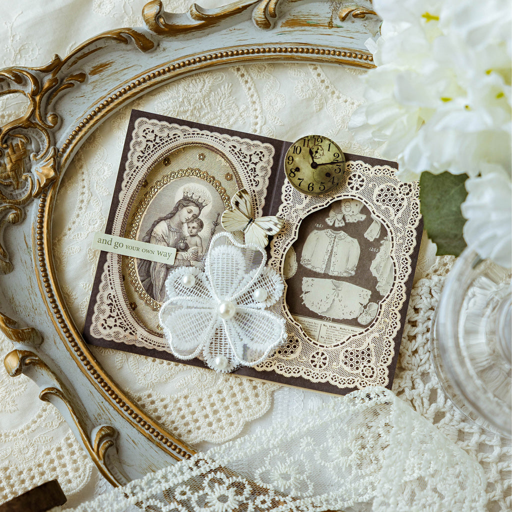 Vintage lace memo pad used in a romantic journal spread with pearls, butterflies, and a brass clock